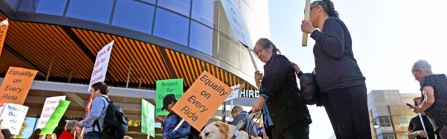 People with blindness and their allies rally outside Uber and Lyft over ride denials